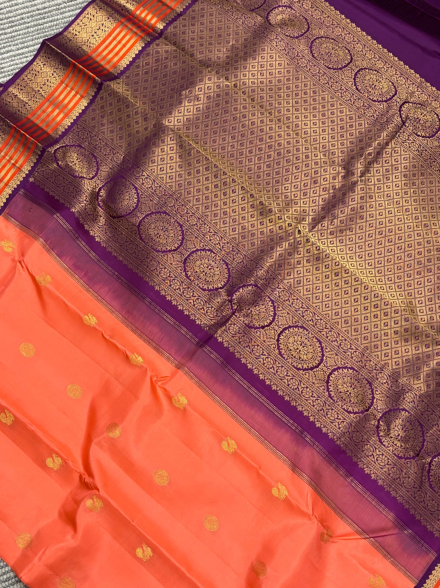 Elegant Peach‑Orange Silk Saree Featuring Classic Purple Highlights & Traditional Zari Accents