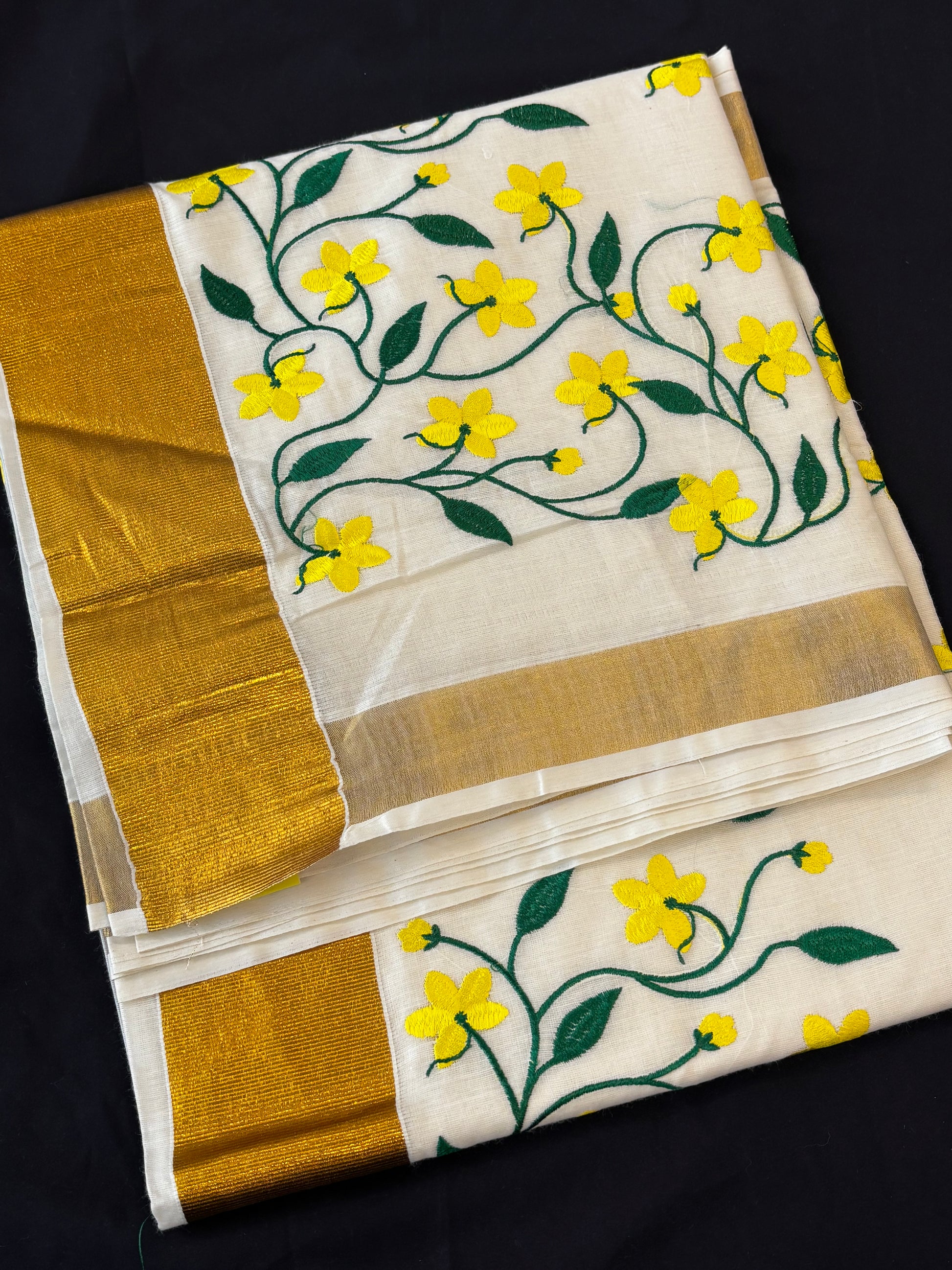 Kerala Kasavu saree with yellow floral and green vine embroidery