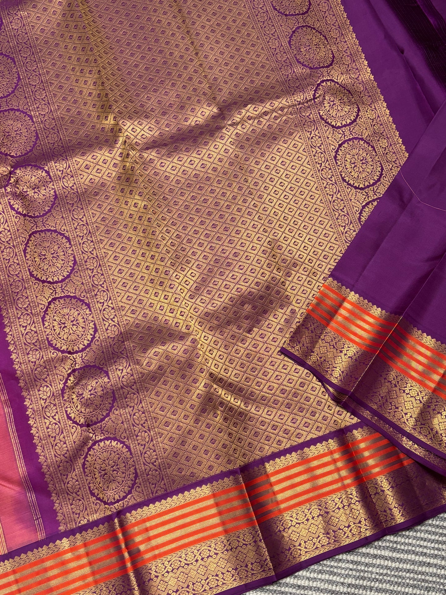 Elegant Peach‑Orange Silk Saree Featuring Classic Purple Highlights & Traditional Zari Accents